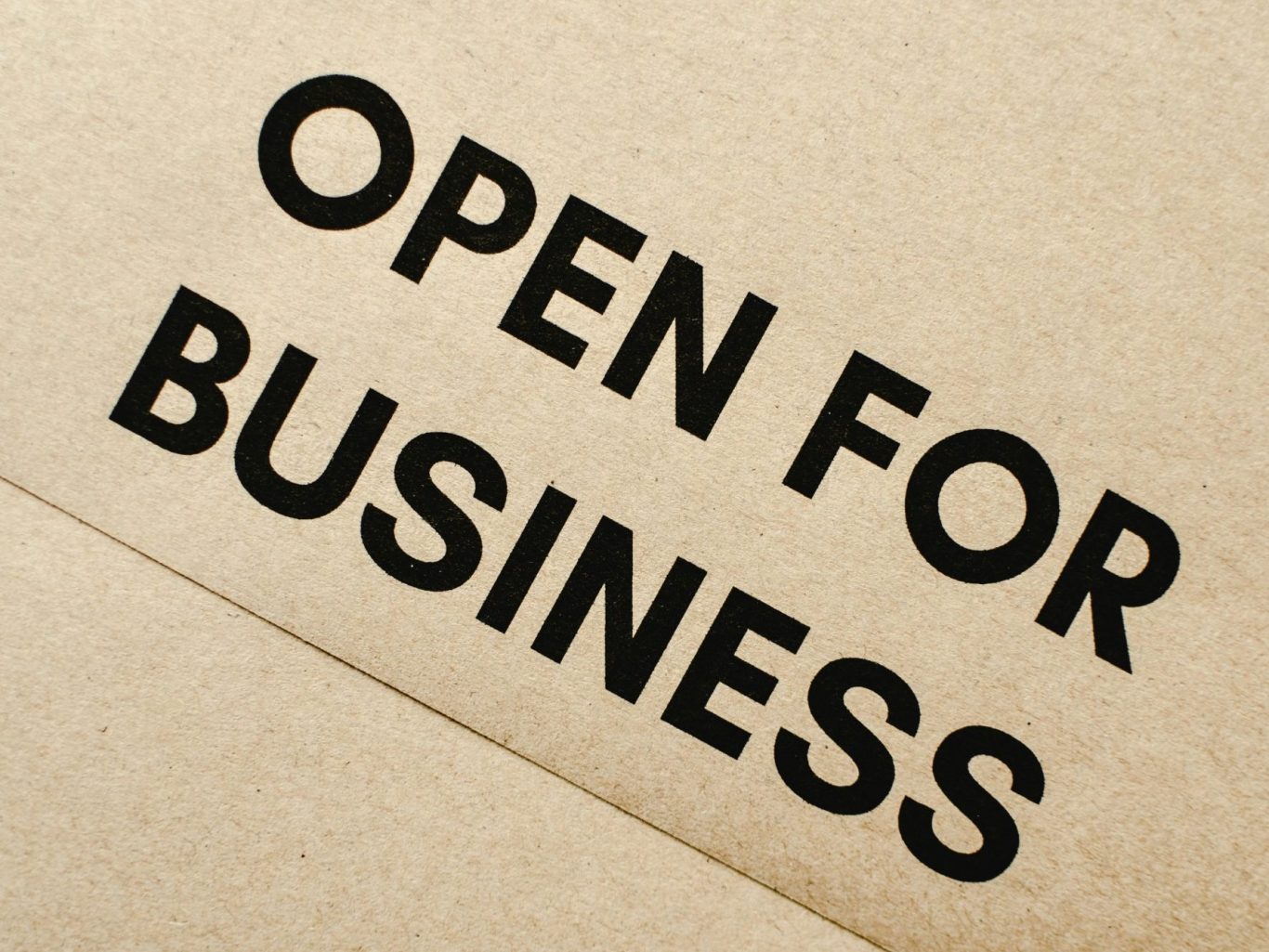 OPEN FOR BUSINESS Texte en noir sur fond beige : "OPEN FOR BUSINESS".